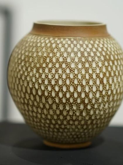This is one of my favorite surface decoration techniques. I apply a layer of white slip over the pot and then carve through it to create these intricate, dotted patterns.