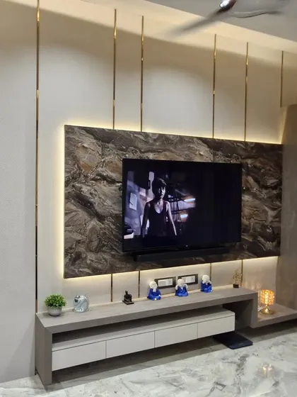A TV unit can be the statement piece of your living room. For this space, I used a combination of a dark marble-finish panel, soft backlighting, and sleek metal inlays to create a modern and luxurious entertainment center.