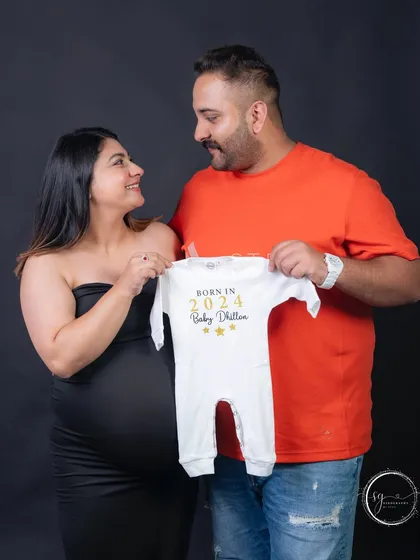 A creative pregnancy announcement featuring a personalized baby onesie. This is a wonderful way for couples to share their excitement and the year their new journey begins.
