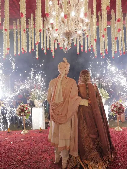 A view from behind the couple shows the scale of the celebration and the joy of their guests, all framed by a spectacular fireworks display I coordinated for their special moment.