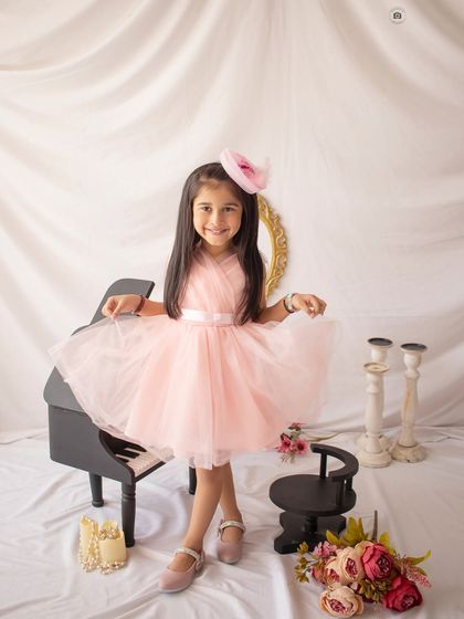 A happy twirl in a pink dress! This shot captures the joy and movement of a fun, piano-themed birthday session.