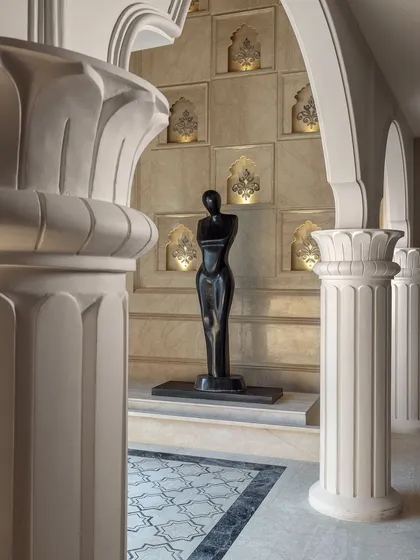 Another view of the sculpture, framed by classical columns and illuminated wall niches. This space was meticulously designed to create a sophisticated environment that showcases both exquisite jewellery and fine art.