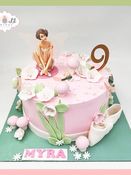 A whimsical fairy cake for Myra's 9th birthday, featuring a delicate fairy, ballet slippers, and soft floral details.