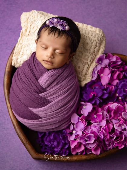 A rich, monochromatic portrait using shades of purple for the wrap, flowers, and background.