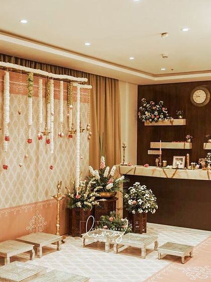 A heritage-themed engagement decor setup in a home. The space is transformed with traditional elements, a beautiful floral backdrop, and elegant seating for the ceremony.