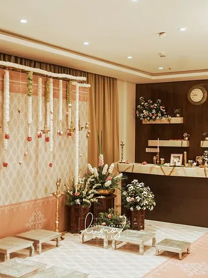 A heritage-themed engagement decor setup in a home. The space is transformed with traditional elements, a beautiful floral backdrop, and elegant seating for the ceremony.