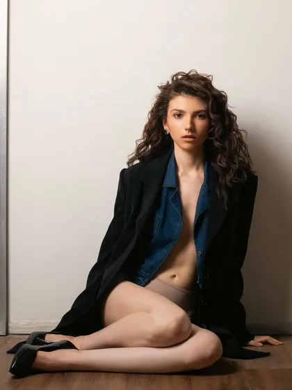 This shot shows the full look, which is all about soft textures, from the curly hair to the cozy jacket. The minimal makeup complements the understated, chic vibe.