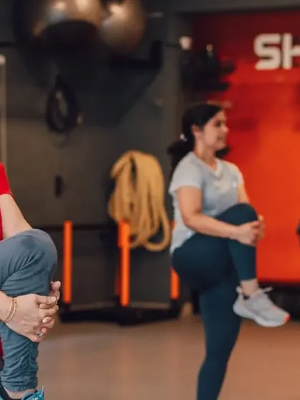 Proper warm-ups are key to a safe and effective workout. Here, members are guided through dynamic stretches like knee hugs to prepare their bodies for a strength session.
