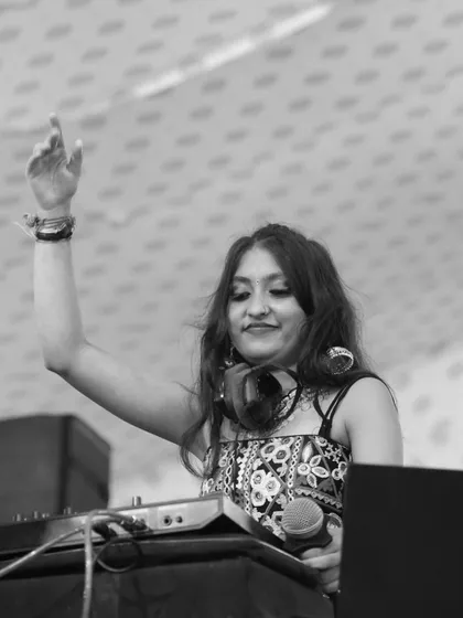A black and white photo of me with my hand up, feeling the rhythm of the dandiya beats.