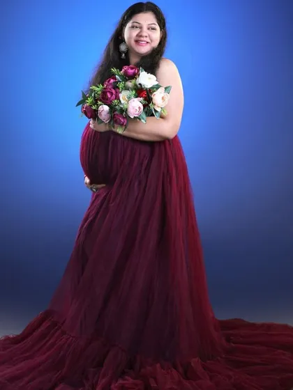A classic studio maternity portrait. This deep wine-colored tulle gown with a full train creates a look of timeless elegance.