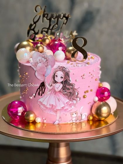 An adorable anime-style cake for an 8th birthday. The soft pink cake is decorated with shiny spheres and a cute character print.