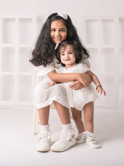 A sweet embrace. This portrait perfectly captures the loving and protective nature of an older sister.