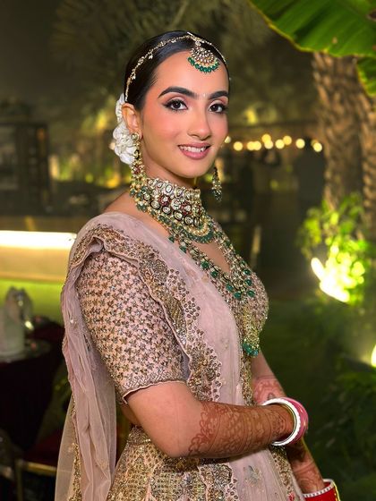 An evening shot of the bride, where her glowing makeup catches the light beautifully. The soft glam look transitions perfectly from a day ceremony to an evening reception.