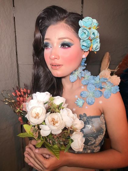 A beautiful portrait holding a bouquet of white flowers, which complements the blue and white tones of this frosty, winter-inspired look.