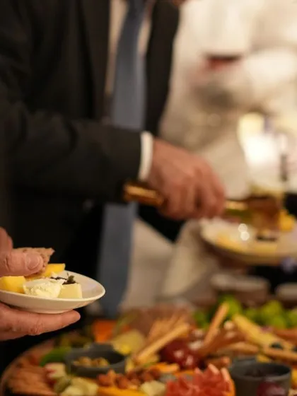 A guest enjoys a plate of selections from our grazing table. This candid shot captures the enjoyment and social atmosphere our food helps to create at corporate events.