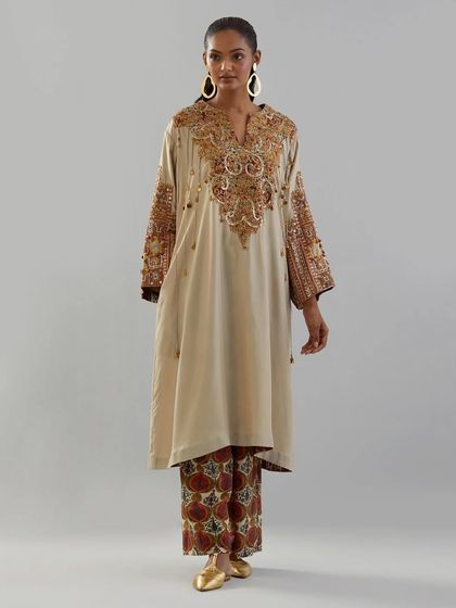 An elegant beige kurta with intricate, multi-colored embroidery on the neckline and sleeves, paired with patterned palazzo pants.