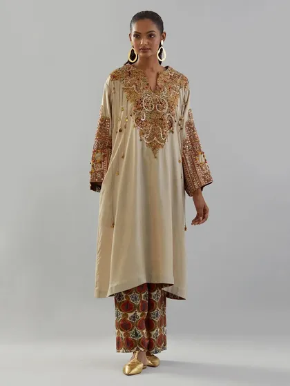 The art of handwork. This beige kurta is brought to life with a heavily embroidered yoke in shades of rust and gold, a beautiful tribute to traditional craftsmanship.