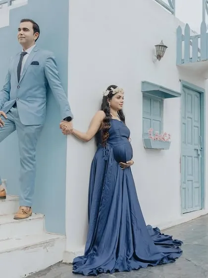 This stylishly posed shot against a Santorini-themed backdrop shows how we can create a high-fashion look. The coordinating outfits and setting make for a memorable couple portrait.