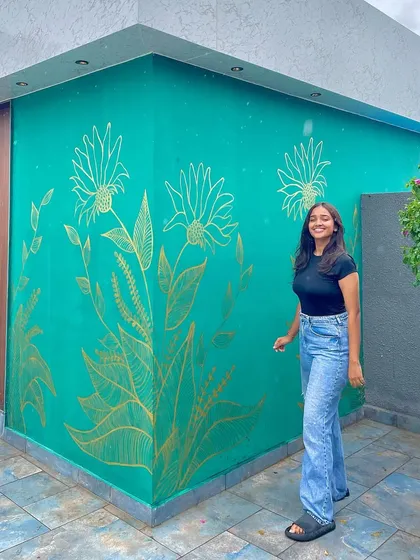 Beyond mandalas, I love creating nature inspired murals. This piece features delicate floral line art in metallic gold against a rich emerald green wall, adding a touch of elegance to an outdoor space.