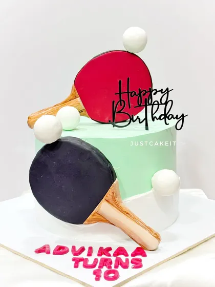A cake for a table tennis player turning 10. The rackets are handmade from fondant, and the design is clean and sporty.
