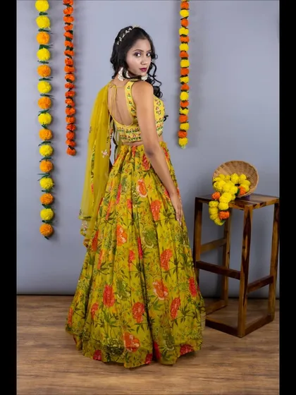 The back view of the floral haldi lehenga, showing the stylish back of the blouse and the light, airy feel of the outfit.