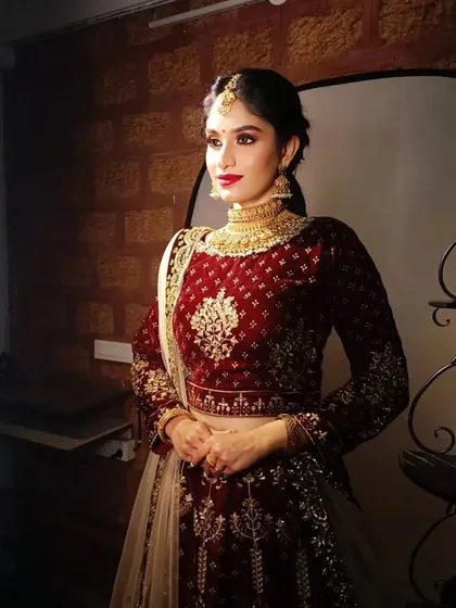 A full-length shot of the model in the velvet lehenga, showing how a traditional choker can be styled with modern outfits.