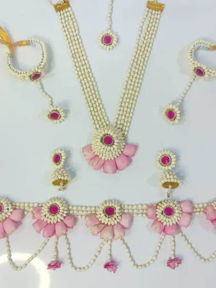 This is a complete floral jewellery set, ready to make you shine. It includes a necklace, maang tika, earrings, hathphool, and a kamarpatta, all handcrafted with pink rose petals and mogra buds for a classic, elegant look.