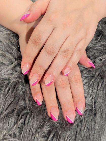 A playful diagonal French tip in bright pink. This angled design adds a fun and modern twist to the classic style.