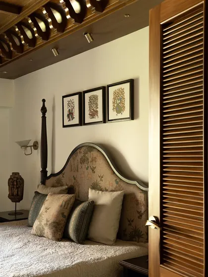 The guest bedroom, with a custom-upholstered headboard and traditional artwork, creating a warm and welcoming space.