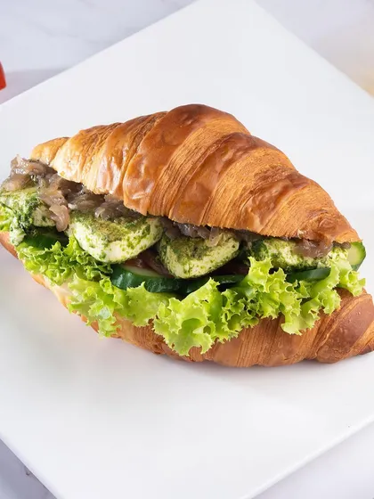 Our Pesto Mozzarella Croissant Sandwich. Fresh mozzarella and vibrant pesto are paired with crisp vegetables for a classic Italian-inspired flavour combination.