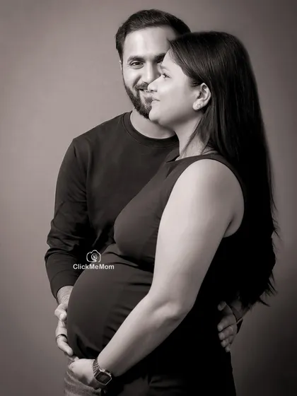 A classic black and white portrait of a couple sharing a quiet, loving moment. The soft lighting and genuine expressions make this a timeless piece of art celebrating their journey to parenthood.