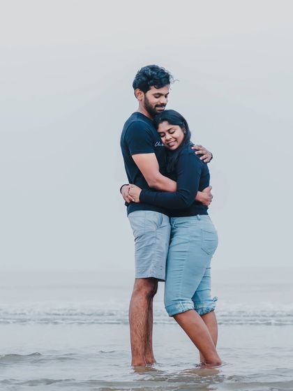 A warm, comforting hug in the shallow waters of the sea, showcasing a moment of quiet connection between the couple.