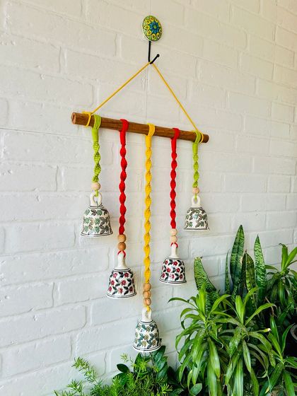 A close-up of our 'Mac & Chime' wall hanging, showing the intricate details of the knotted cotton cords and hand-painted ceramic bells. This piece is a beautiful example of our love for handmade decor.