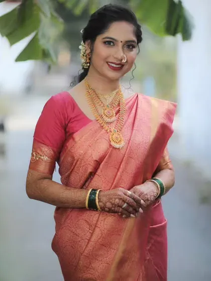 A smiling portrait of the bride, showcasing her complete look, from the makeup to the perfectly draped saree.