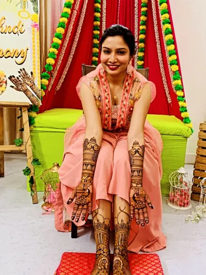 A happy bride on her mehndi day. This is the complete look, with detailed designs covering both hands and feet. I work with you to create a cohesive design that complements your bridal attire and makes you feel special.