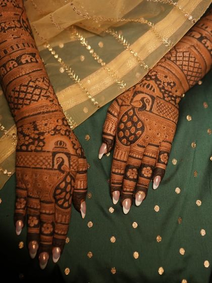 A close-up of a beautiful, dense design perfect for the bride's sister or best friend. It features classic peacock and elephant motifs.