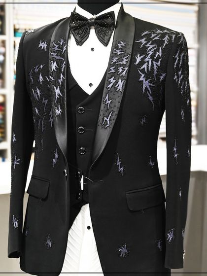A black three-piece tuxedo with abstract silver embroidery. This artistic design is perfect for a client looking for a contemporary and edgy formal look.