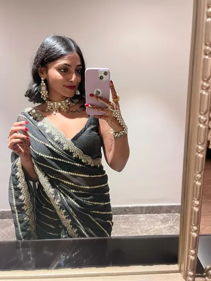 Another mirror selfie capturing the details of the saree's border and my henna-adorned hand. Personal touches are what make an outfit special.