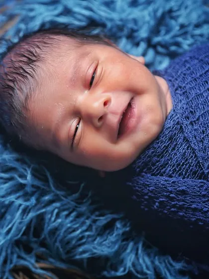A heart-melting smile from a sleeping baby swaddled in blue. These are the magical, fleeting moments I am always ready to capture.