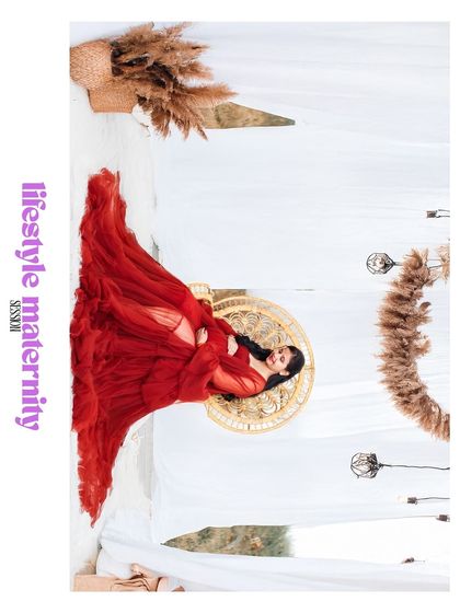 An artistic, rotated image labeled "lifestyle maternity session," showing a woman in a red gown in a stylishly decorated studio.