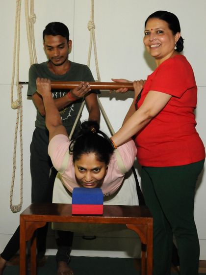 Another view of the supported backbend, showing my hands-on adjustment. My touch is not just to correct, but to guide the student's awareness and energy to the right place, facilitating a deeper release.