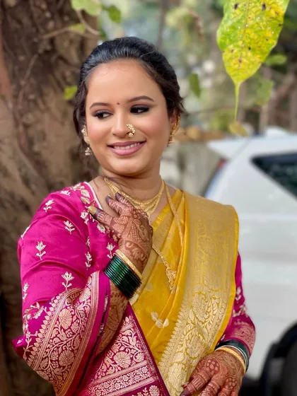 A lovely outdoor shot where her radiant makeup looks fresh and natural. The subtle blush and defined eyes are perfect for her Marathi bridal charm.