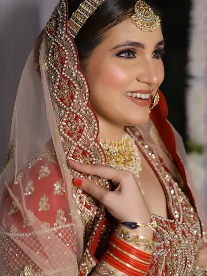 A happy, smiling bride. Her makeup is radiant and fresh, designed to last through a long day of celebrations while keeping her comfortable and glowing.