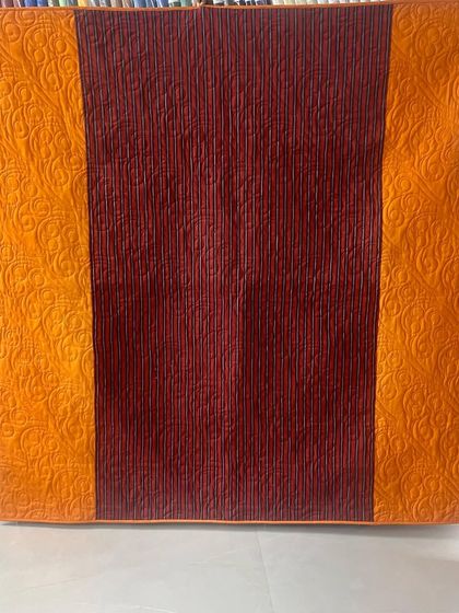 The back of the quilt, featuring a bold orange and red design.