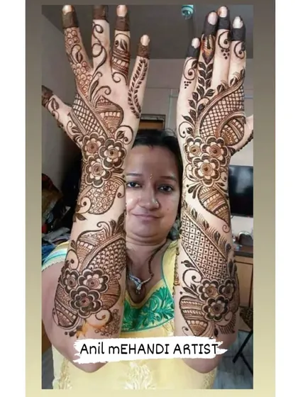 A satisfied client displaying her full-arm floral mehandi. The large, bold flowers create a beautiful and modern look.