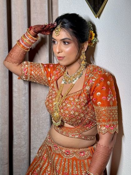 A confident pose showing off the complete look. The makeup, hair, and outfit all come together to create a stunning bridal statement.