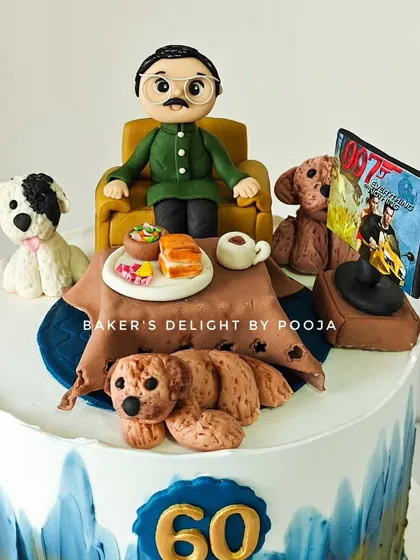 A closer look at the 60th birthday story cake topper, showing the dad figurine with his puppies, a plate of Misal Pav, and a TV showing an action movie.