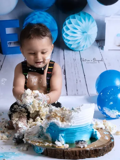 A close-up of the happy mess during a "Boss Baby" themed cakesmash, capturing the baby's joyful expression as he plays with the cake.