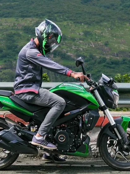 A rider getting on his bike, captured mid-motion during a photoshoot at Nandi Hills.