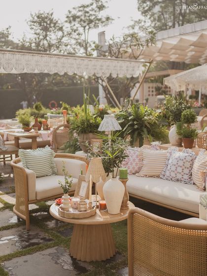 A comfortable lounge area with cane furniture and an abundance of printed cushions, creating a cozy and stylish corner.